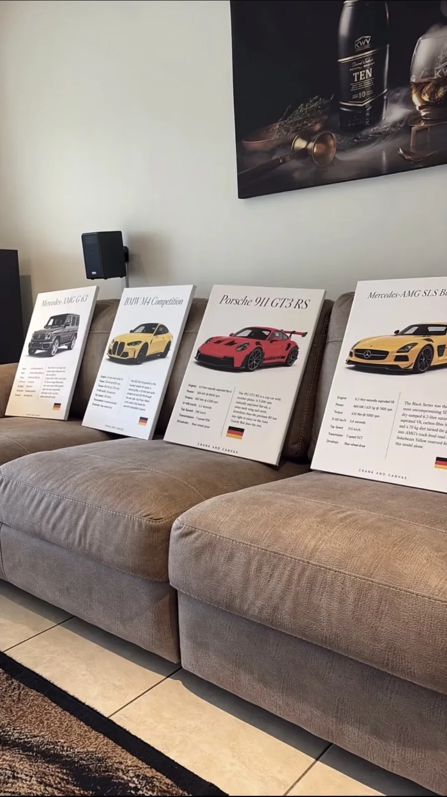 Four commissioned canvases, including a 911 GT3 RS and an SLS Black Series, lined up on a sofa
